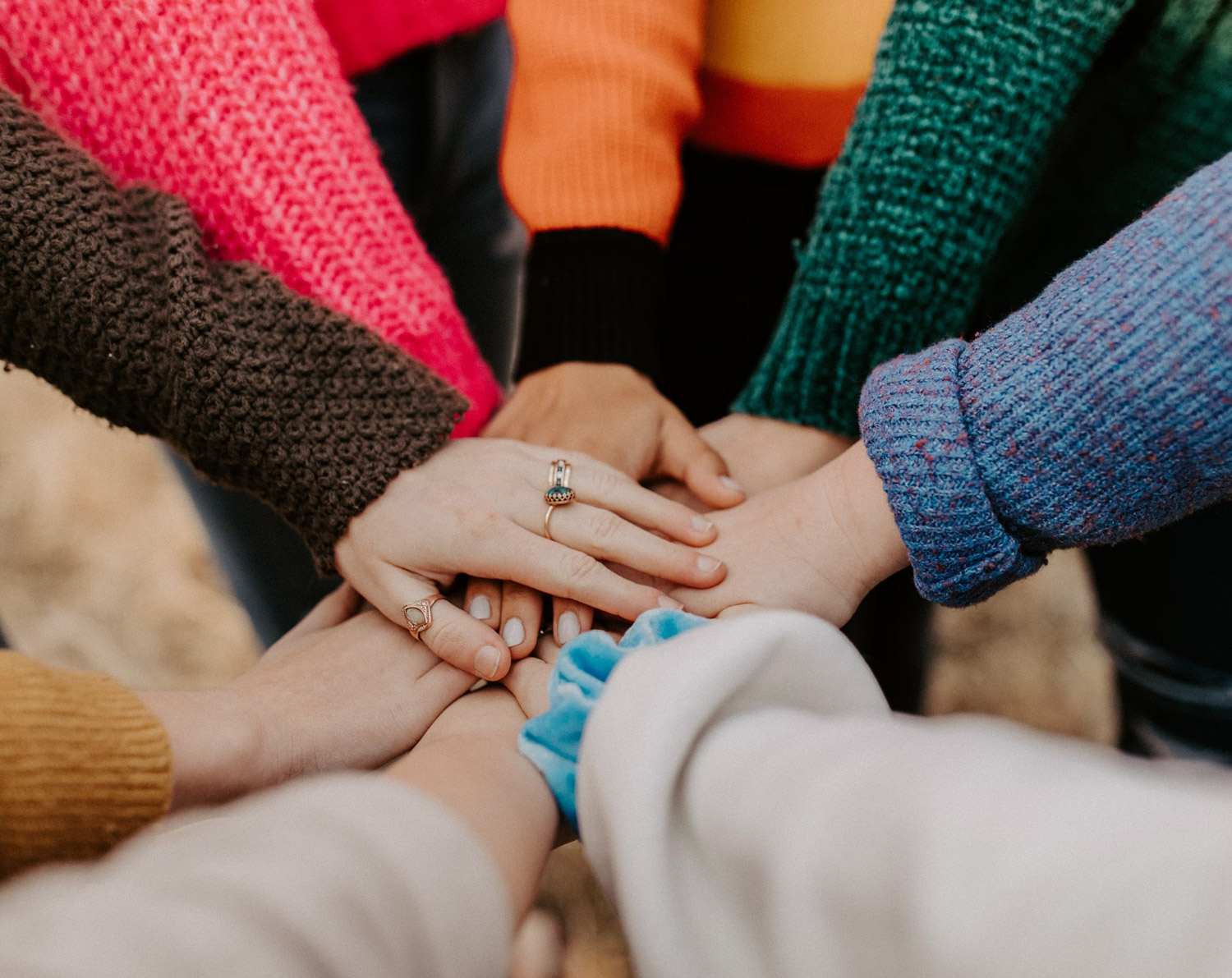 Shows hands in a circle, relating to group therapy