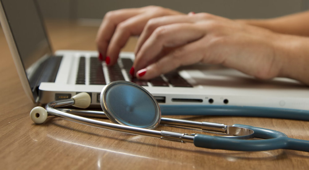 Shows a doctor at a laptop, relating to functional laboratory analysis for Recovery Without Walls patients