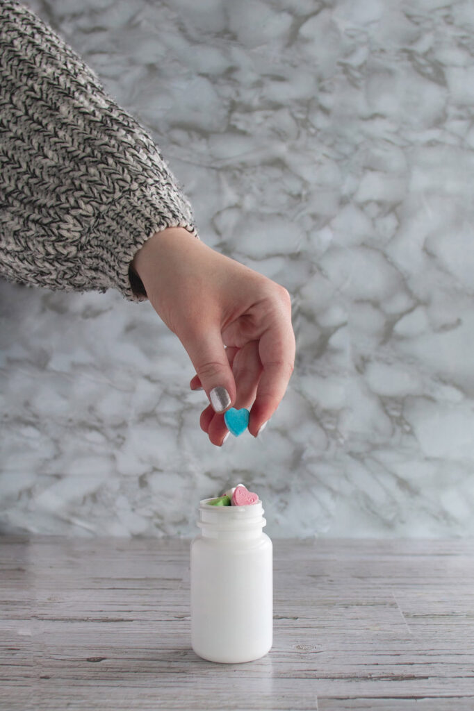 Shows a hand and a prescription pill bottle relating to advanced pharmacology for pain relief